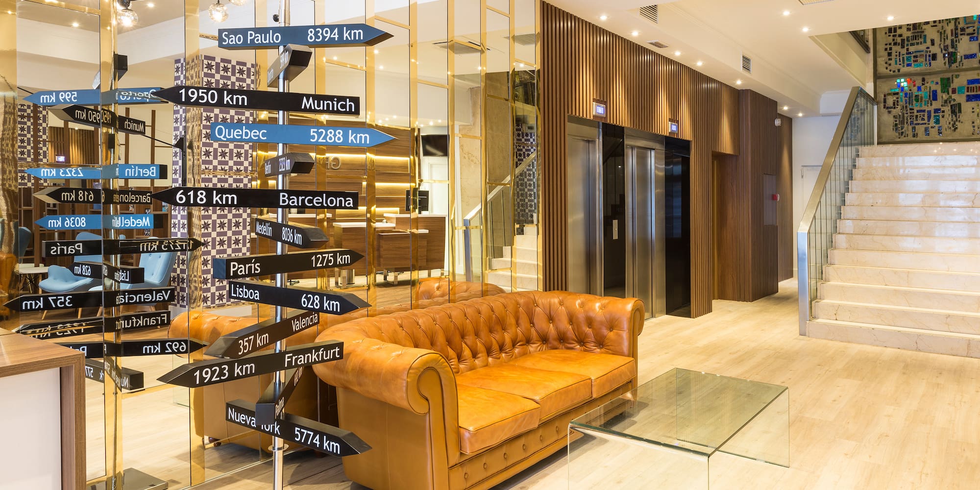 a brown couch with black signs in front of a glass wall