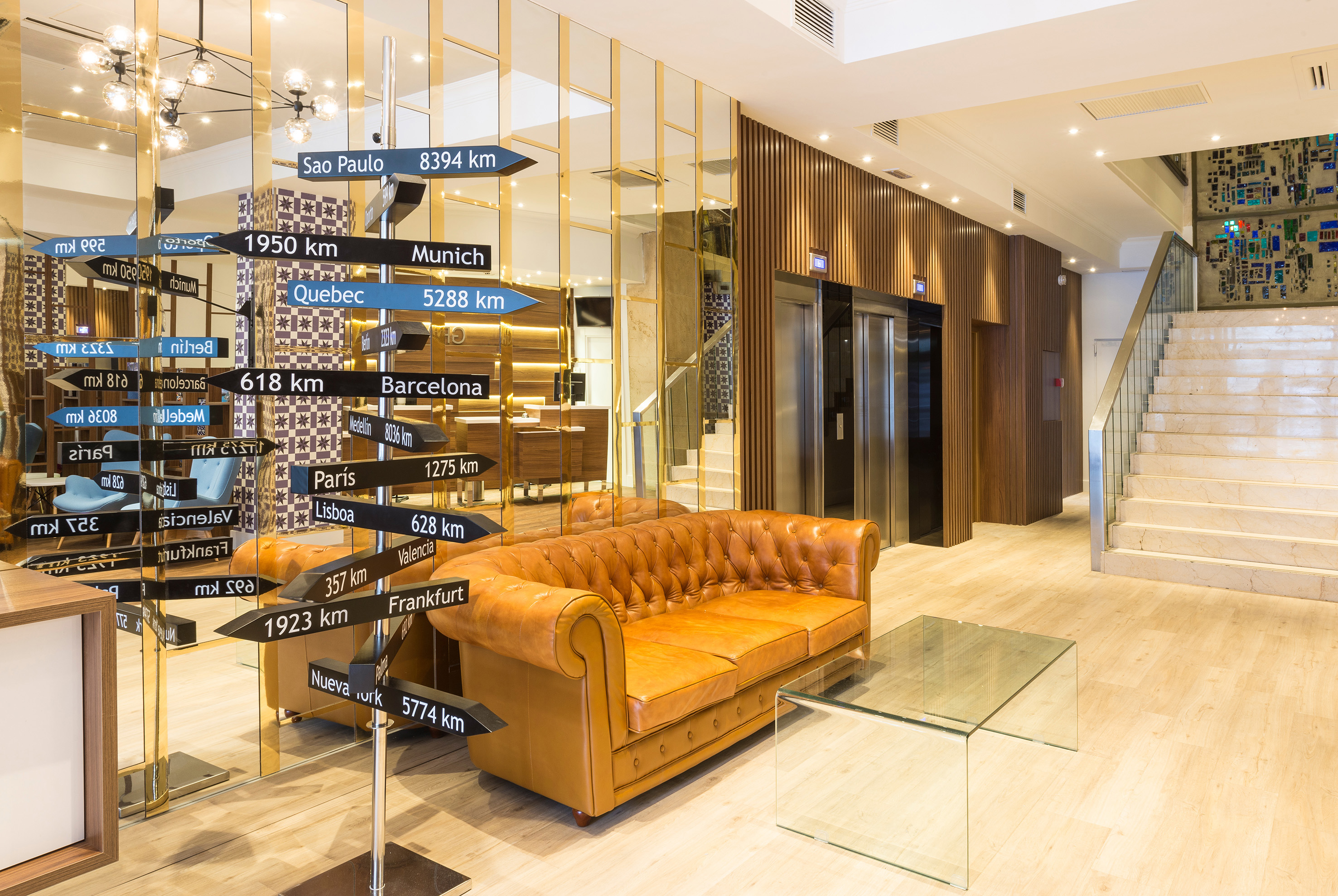 a brown couch with black signs in front of a glass wall