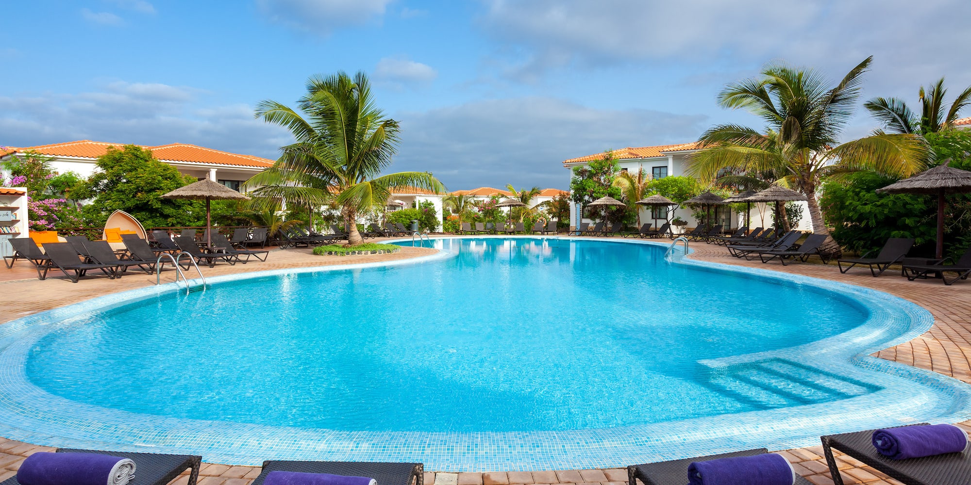 a pool with lounge chairs and umbrellas