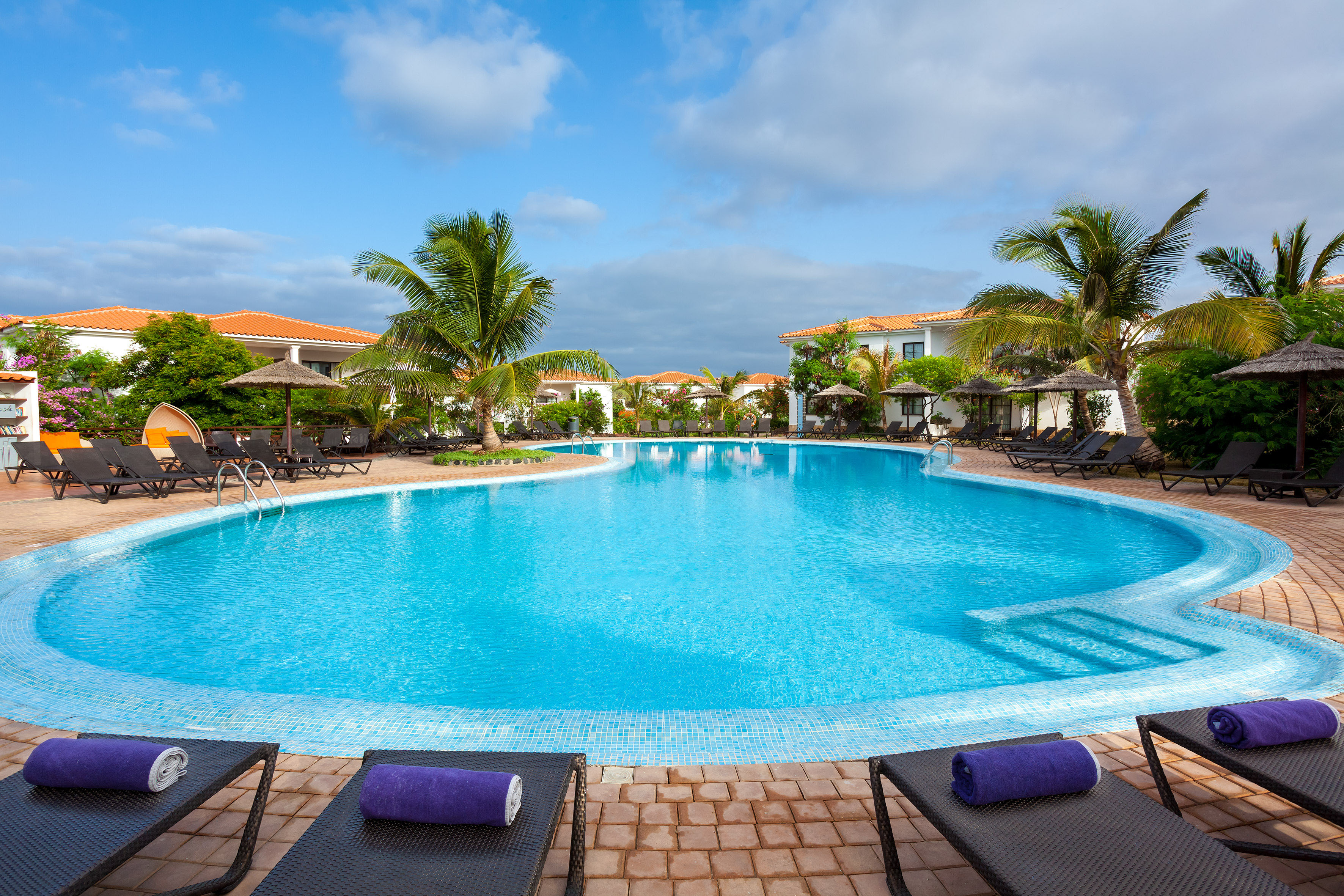 a pool with lounge chairs and umbrellas