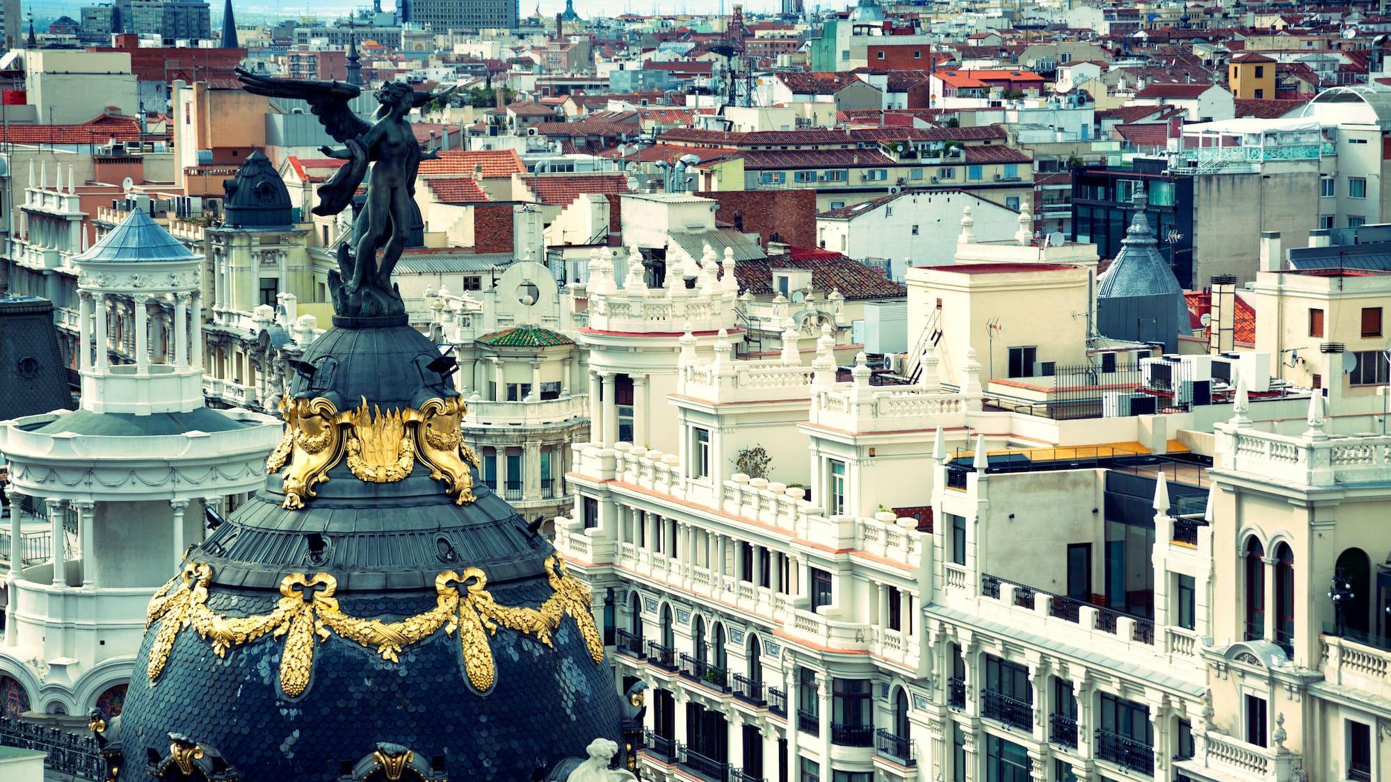 a city with a statue on top of a dome