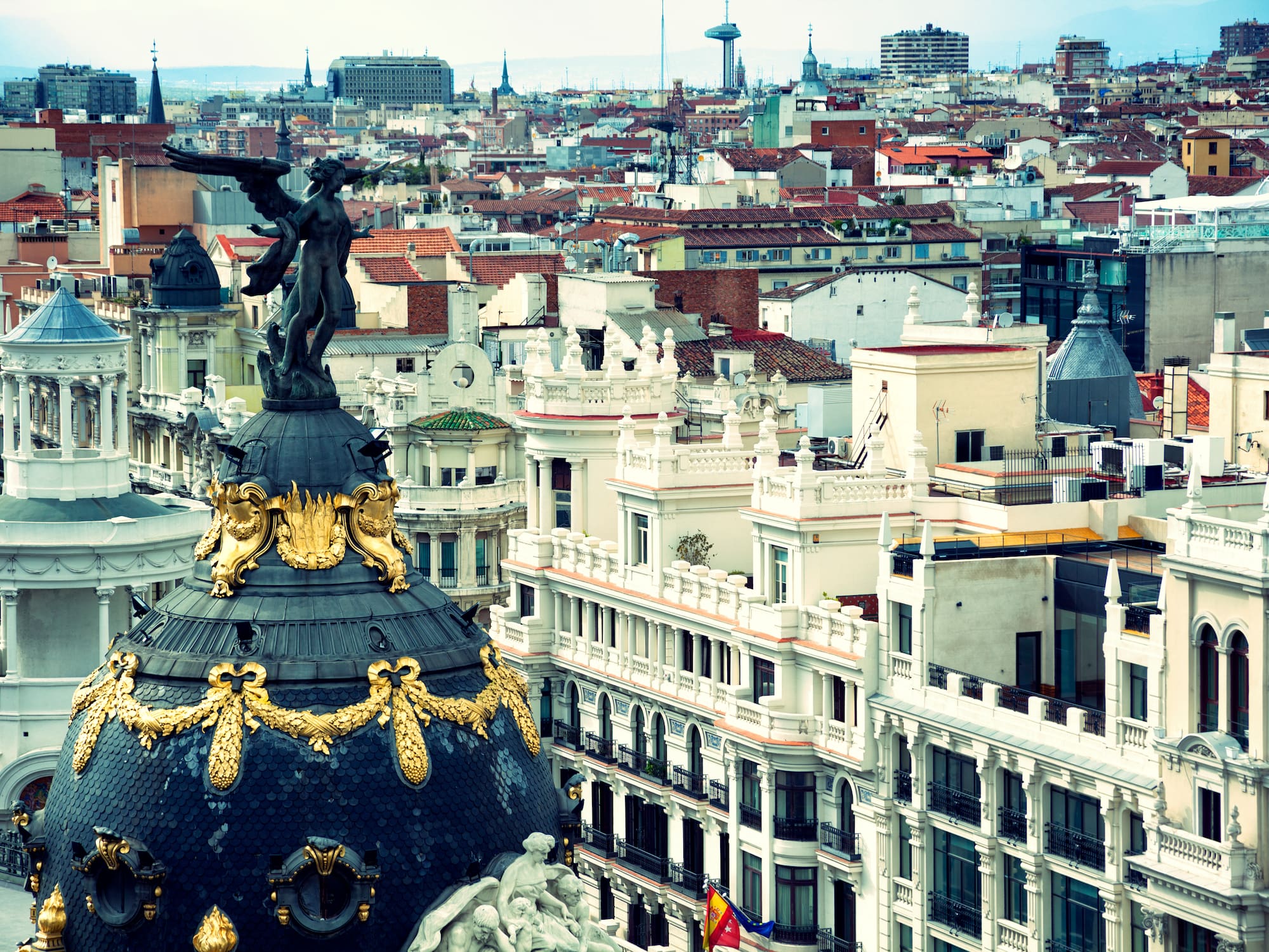 a city with a statue atop a dome