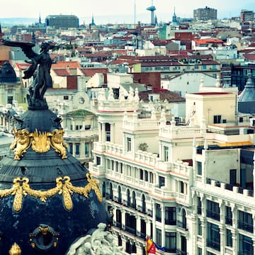 a city with a statue on top of a dome