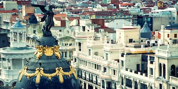 a city with a statue on top of a dome