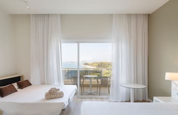 a room with a view of the ocean and a table and chairs