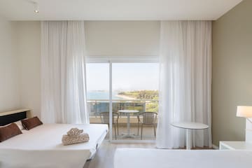 a room with a view of the ocean and a table and chairs