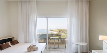 a room with a view of the ocean and a table and chairs