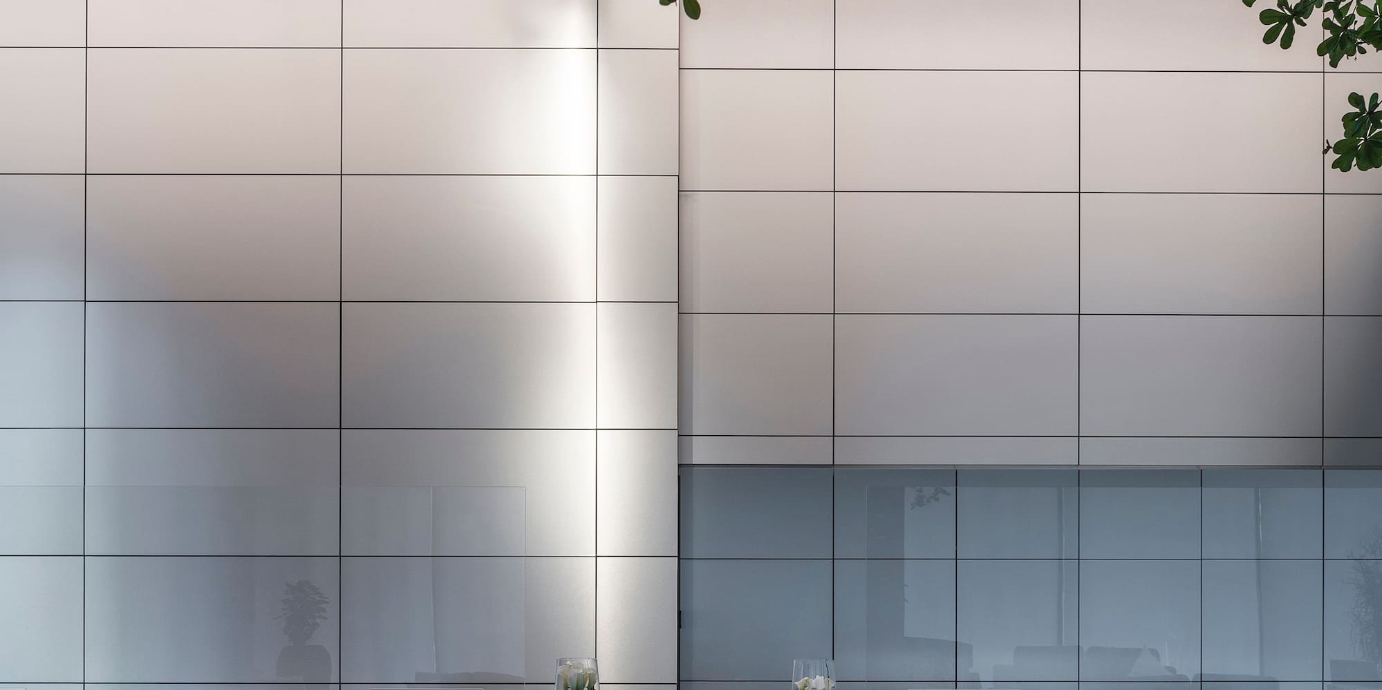 a reception desk with a white wall and a tree