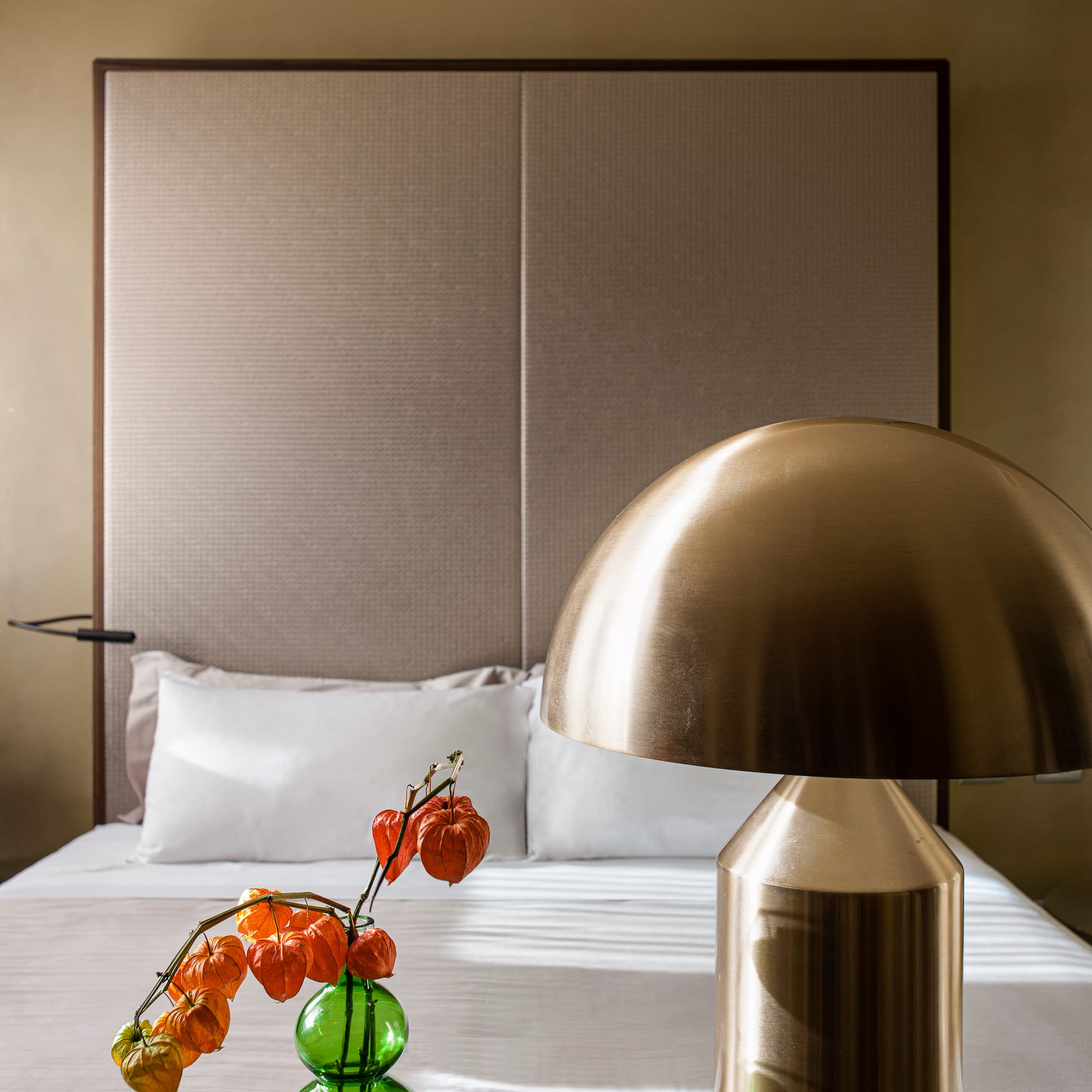 a lamp on a table next to a bed