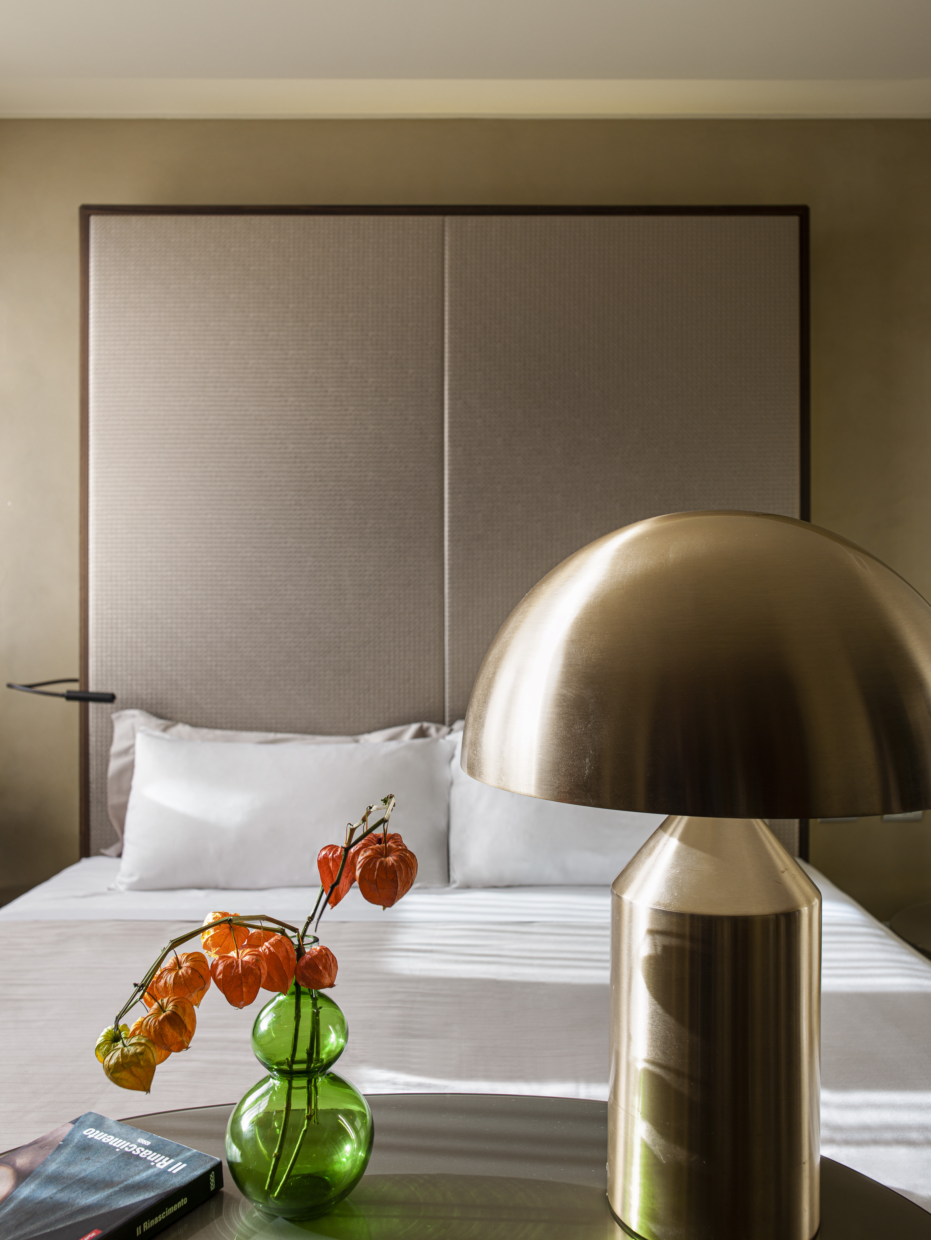 a lamp on a table next to a bed