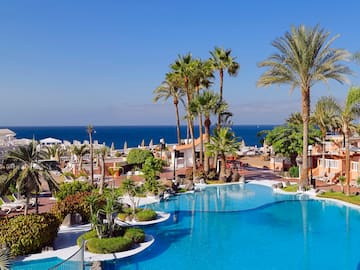 a pool with palm trees and a beach