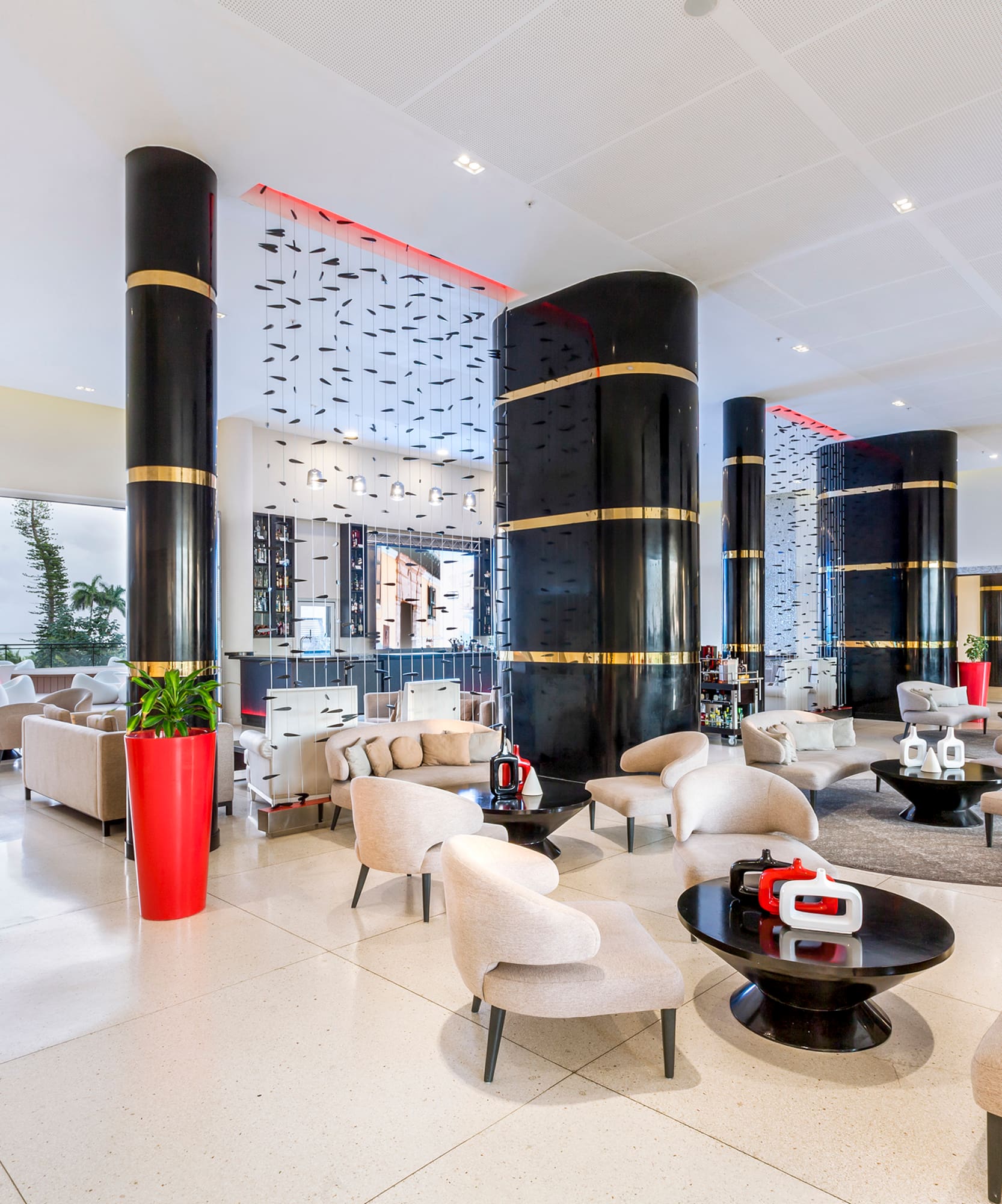 a large lobby with white chairs and black columns