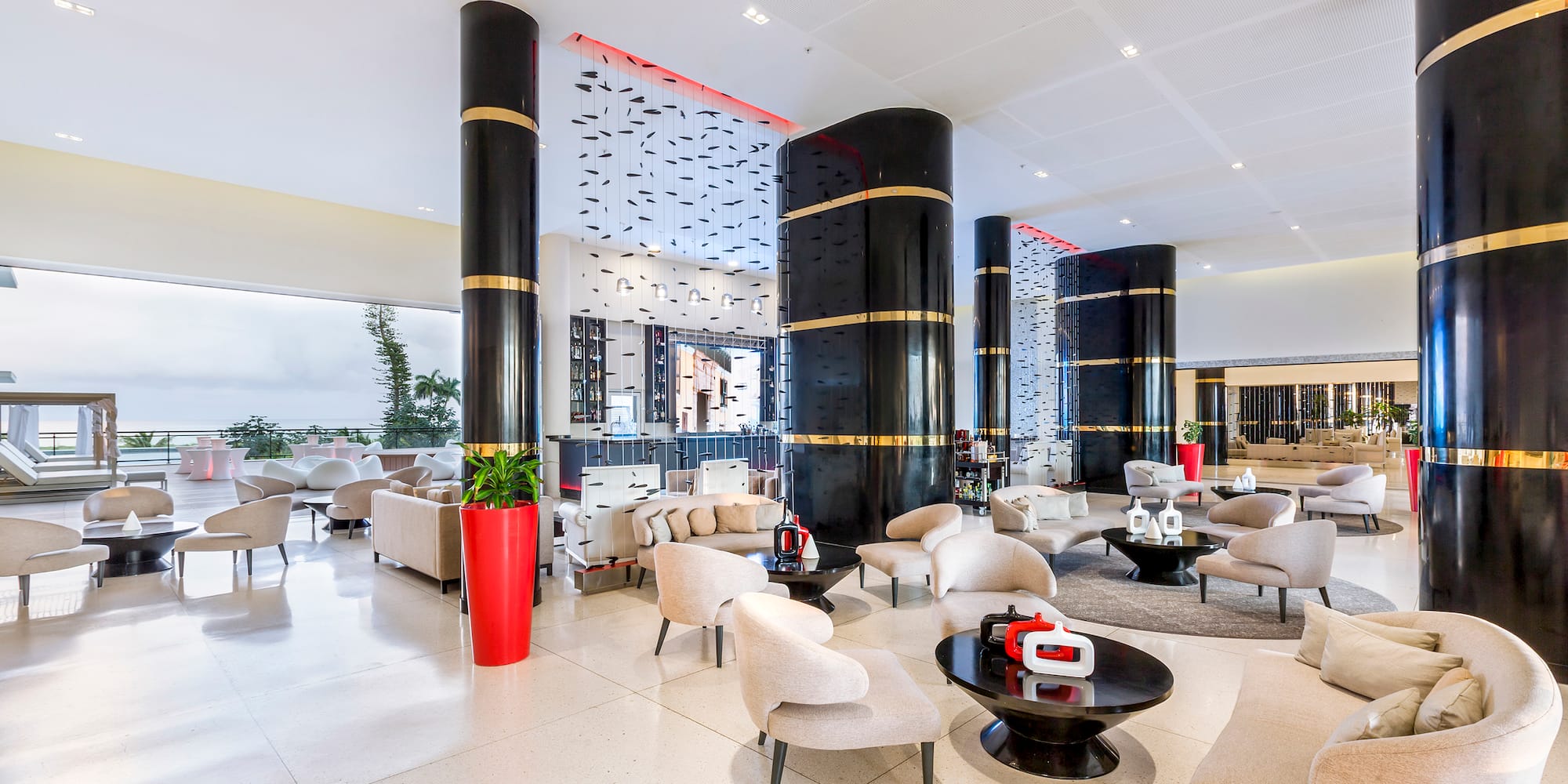 a large lobby with white chairs and black columns
