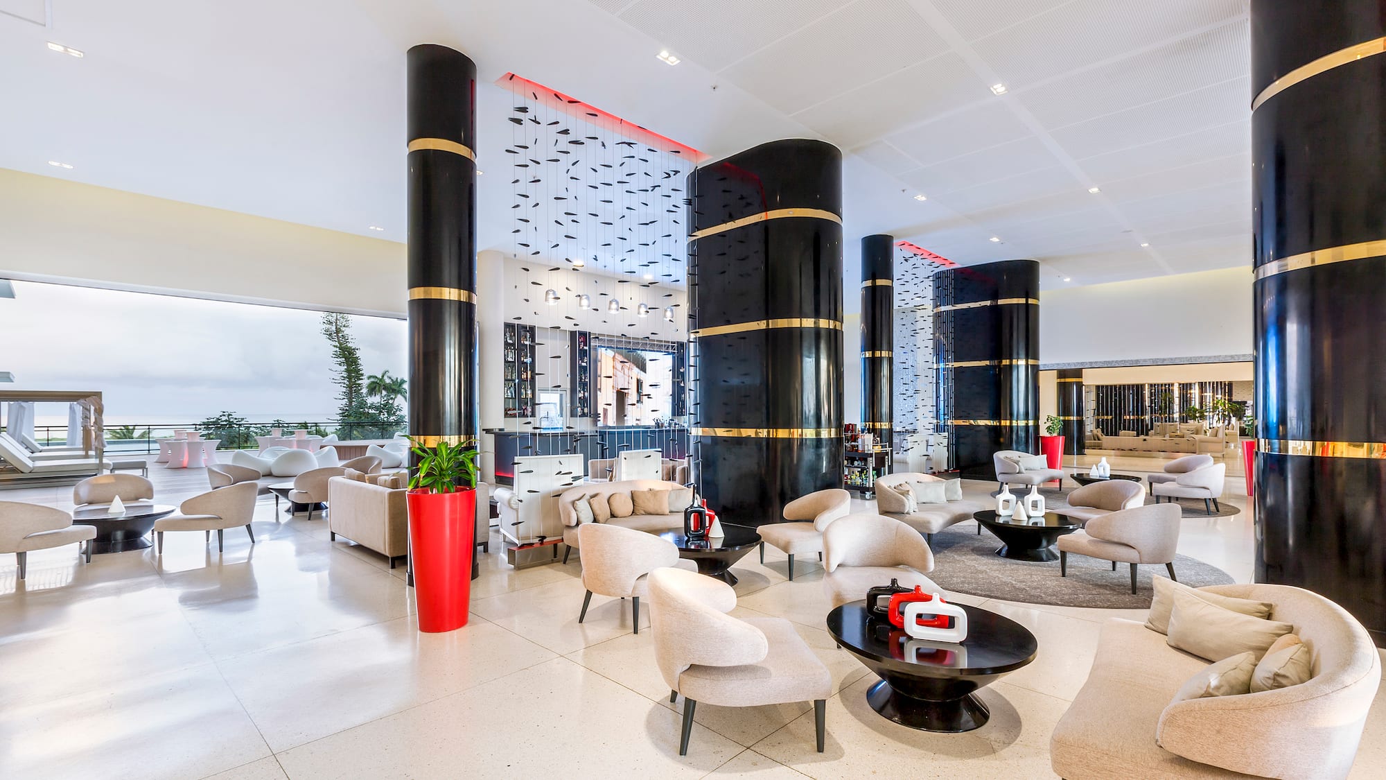 a large lobby with white chairs and black columns