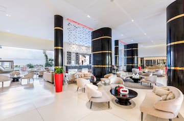 a large lobby with white chairs and black columns