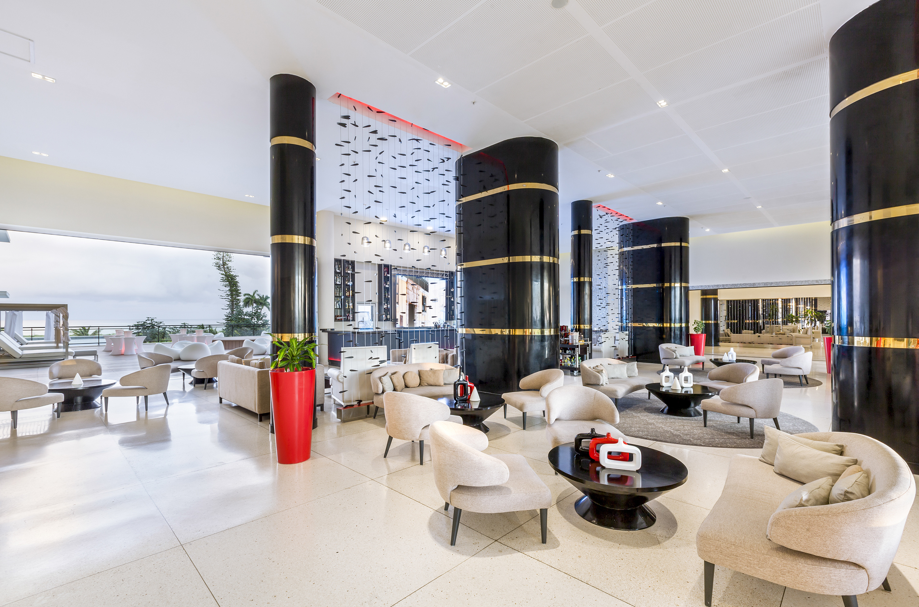 a large lobby with white chairs and black columns