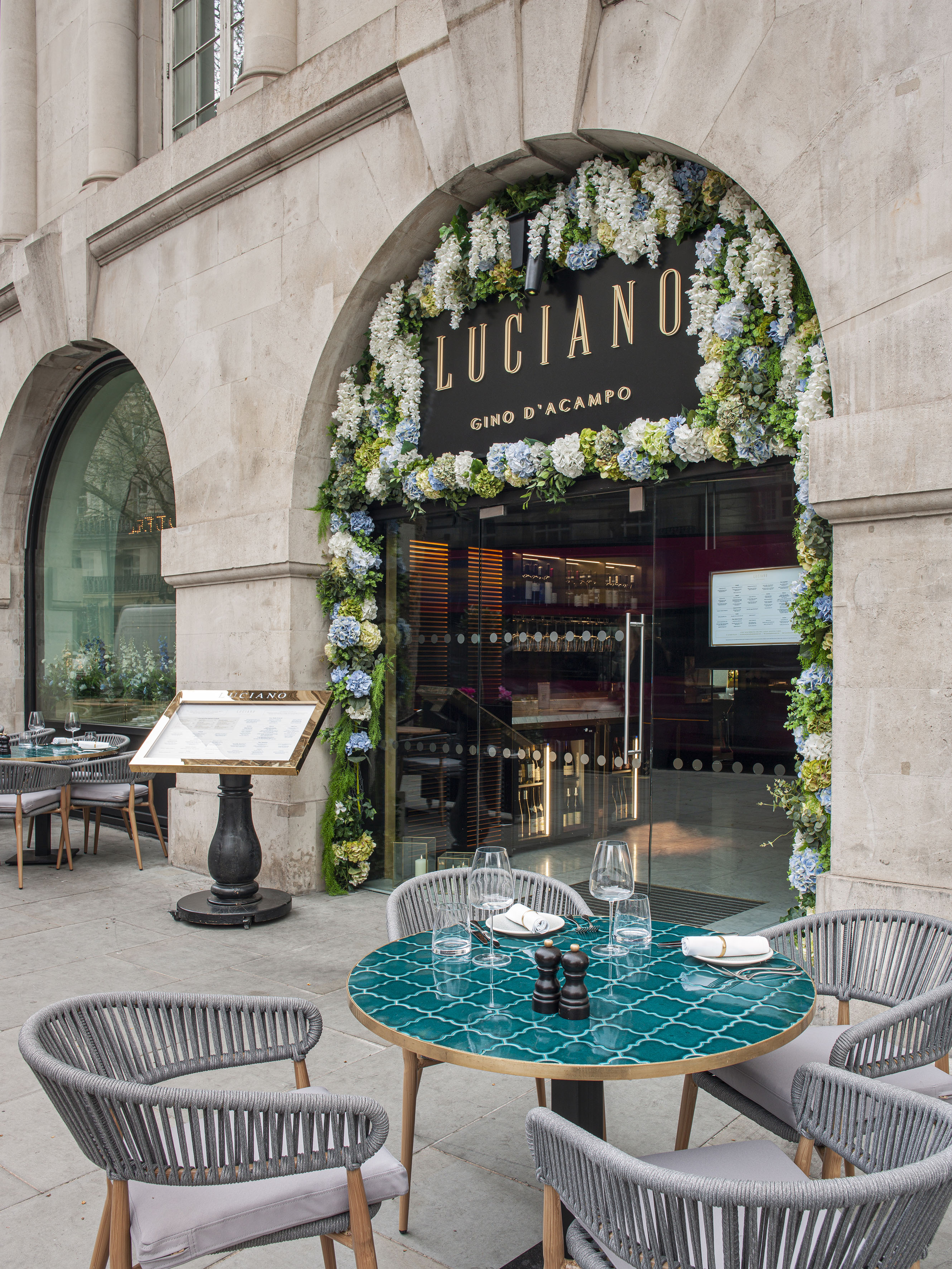 Luciano restaurant exterior with floral archway and outdoor dining patio.