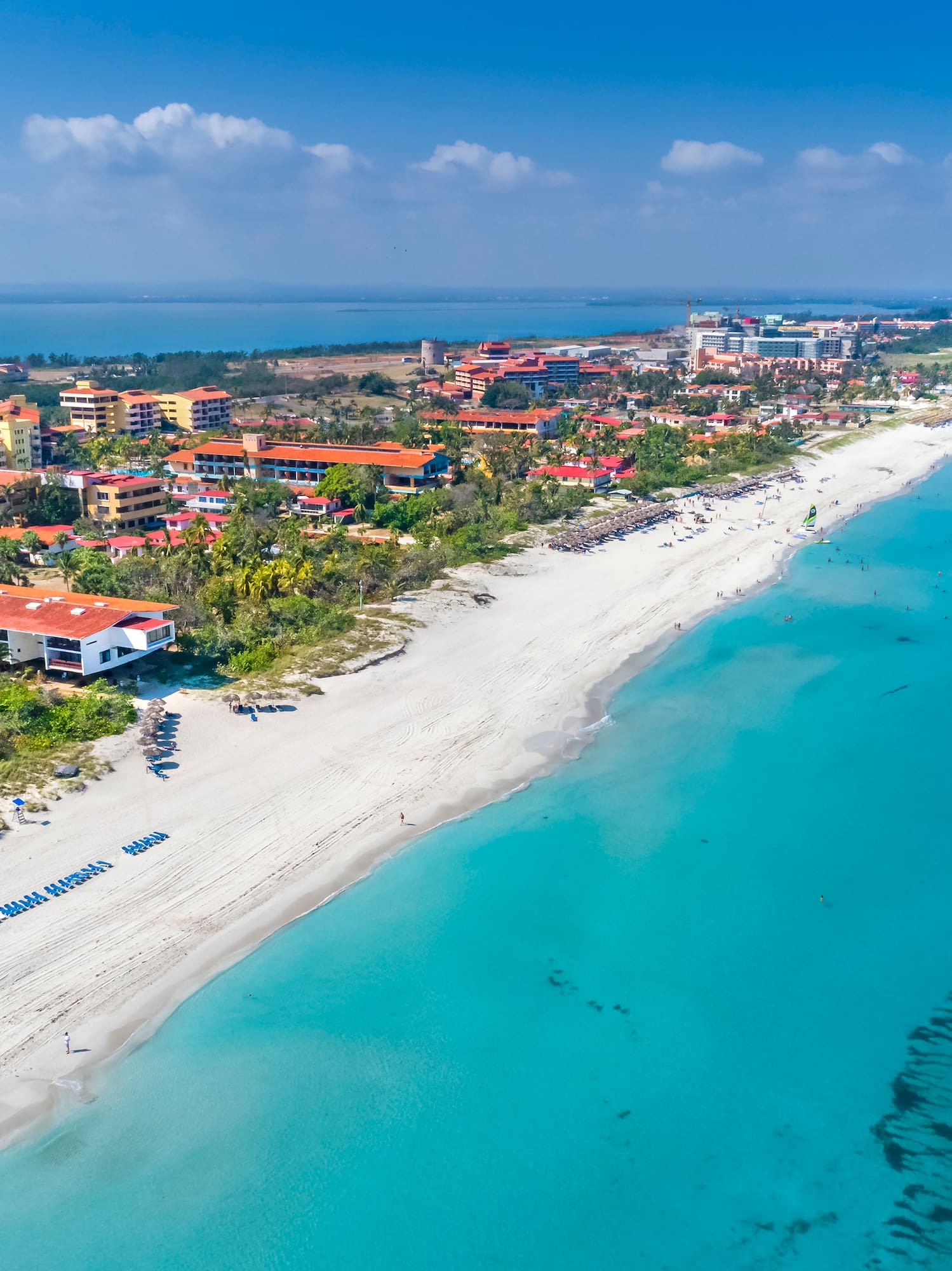 a beach with buildings and blue water