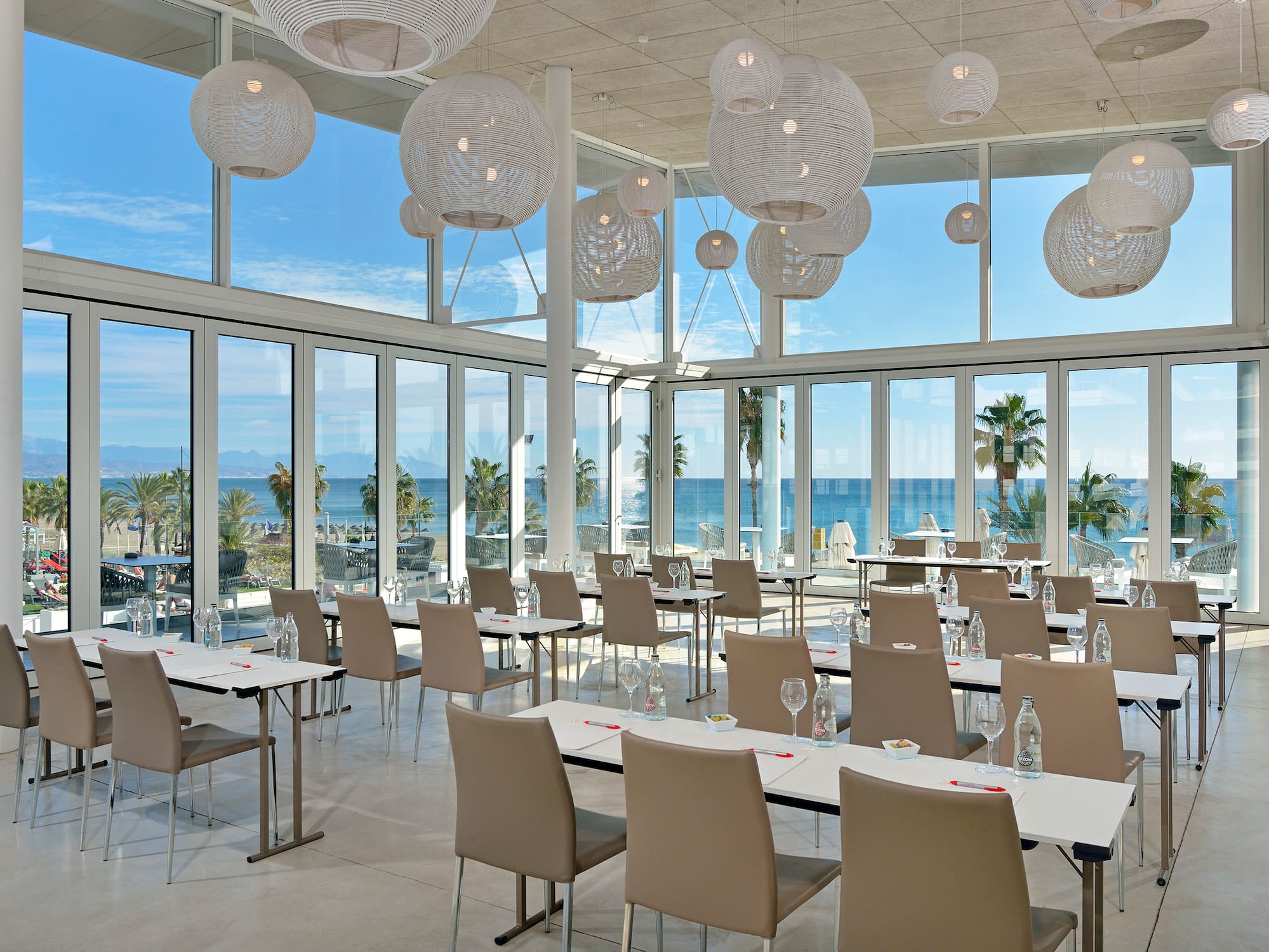 a room with tables and chairs and a large window