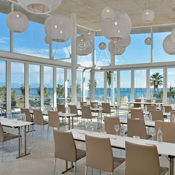 a room with tables and chairs and a large window