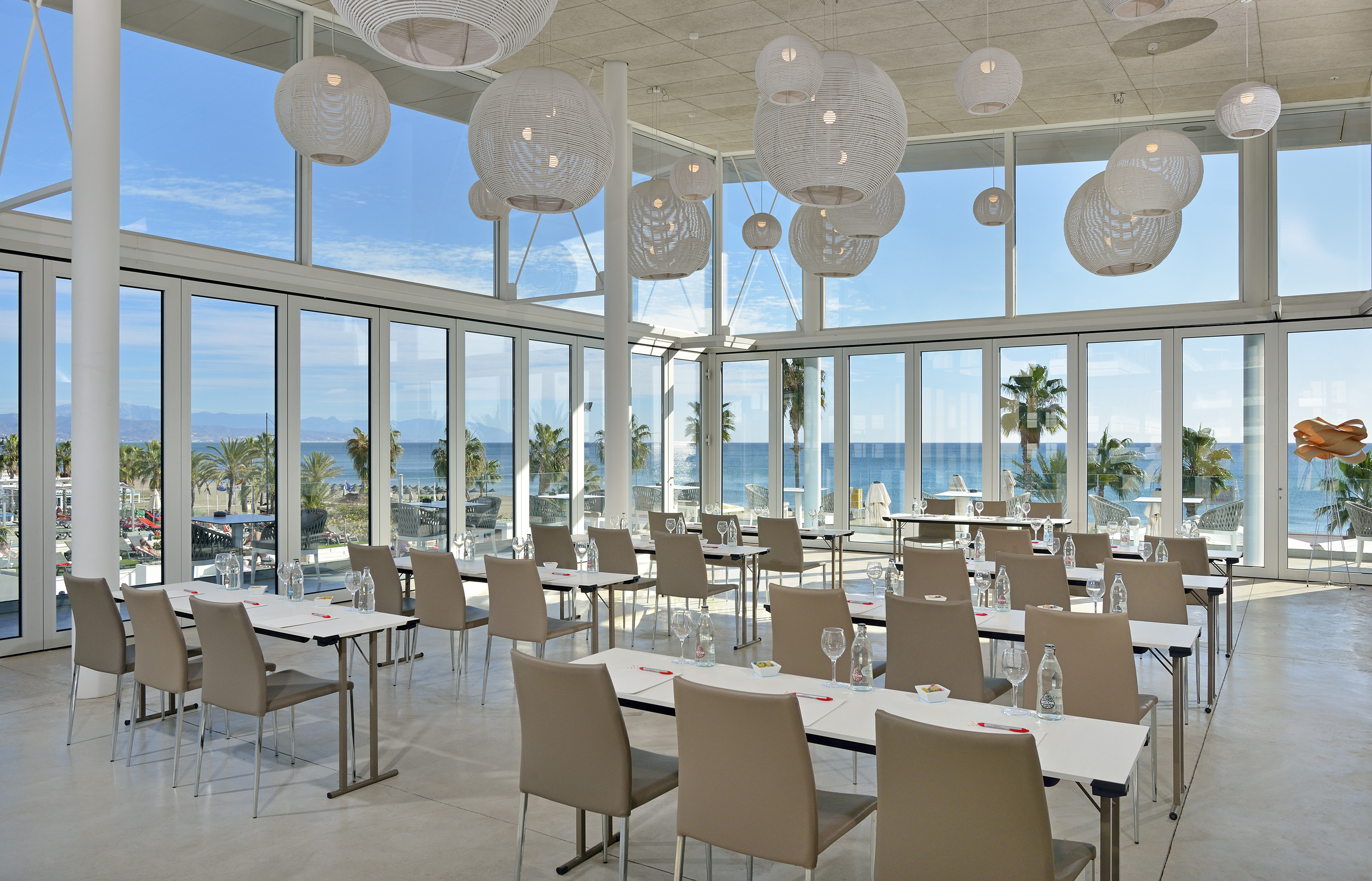 a room with tables and chairs and a large window