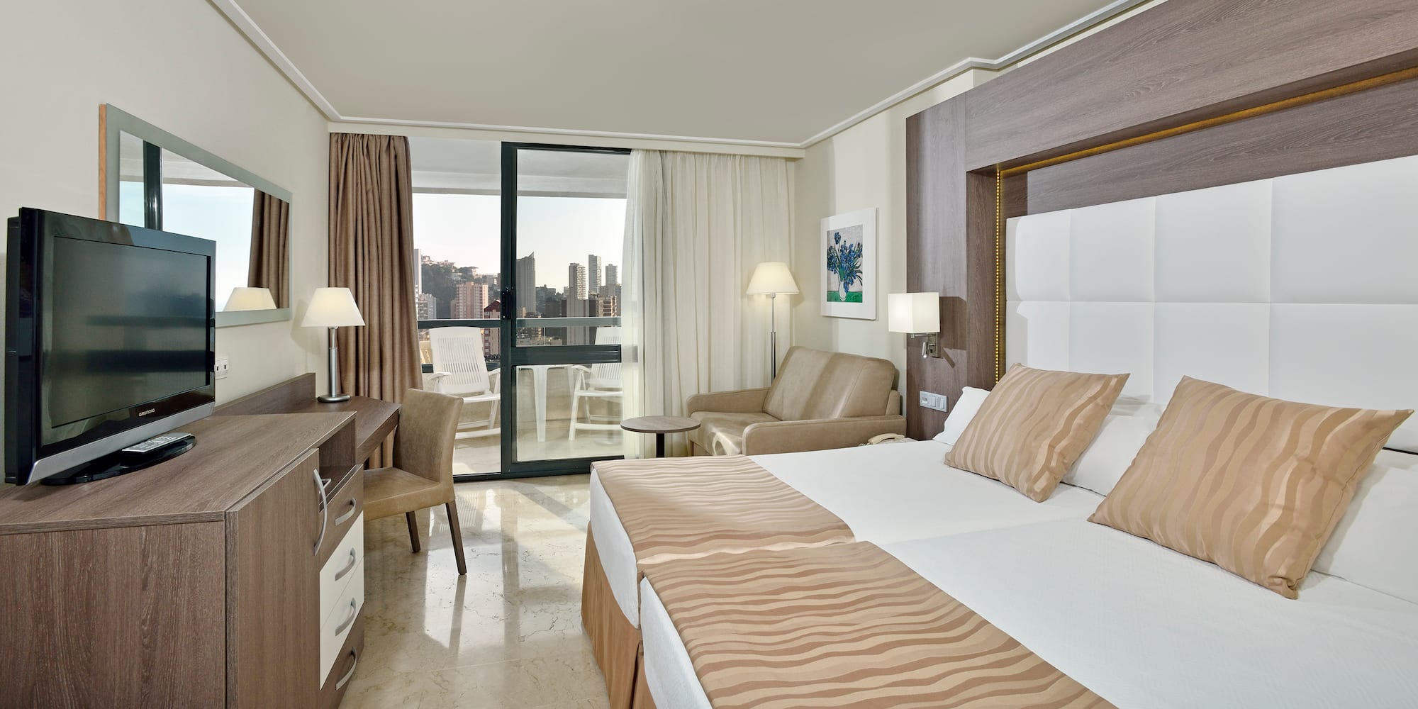 a room with two beds and a table and chairs