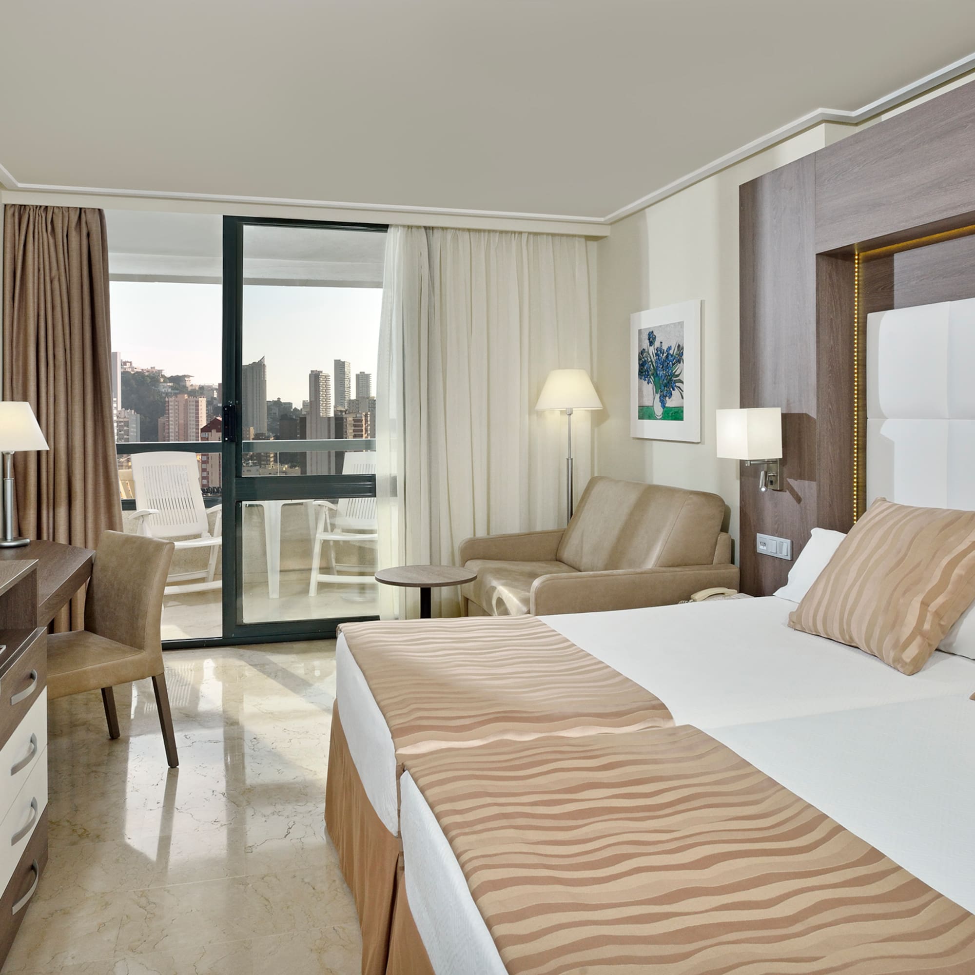 a room with two beds and a table and chairs