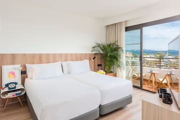 a room with two beds and a glass door