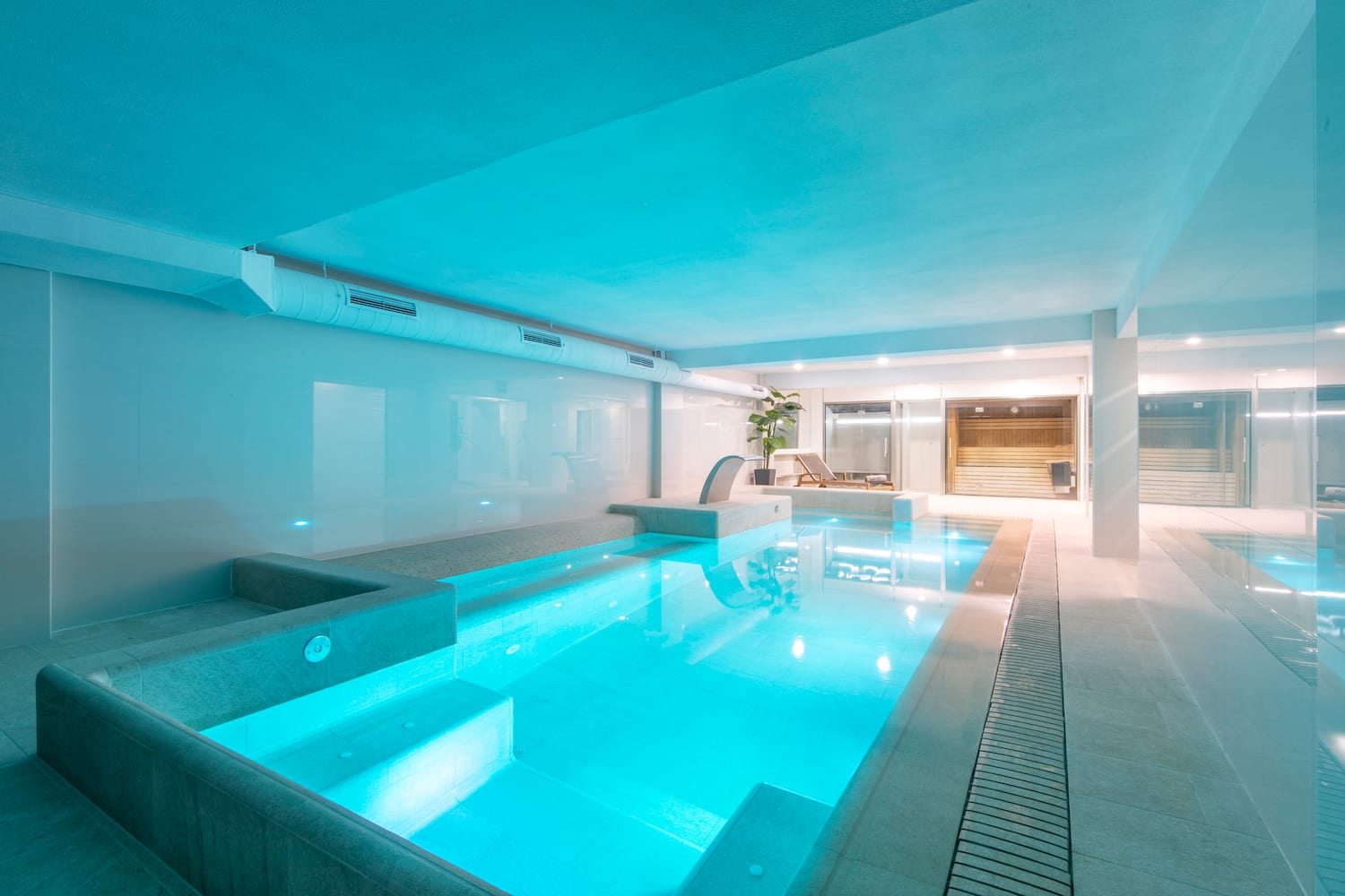 a indoor pool with a deck and a chair