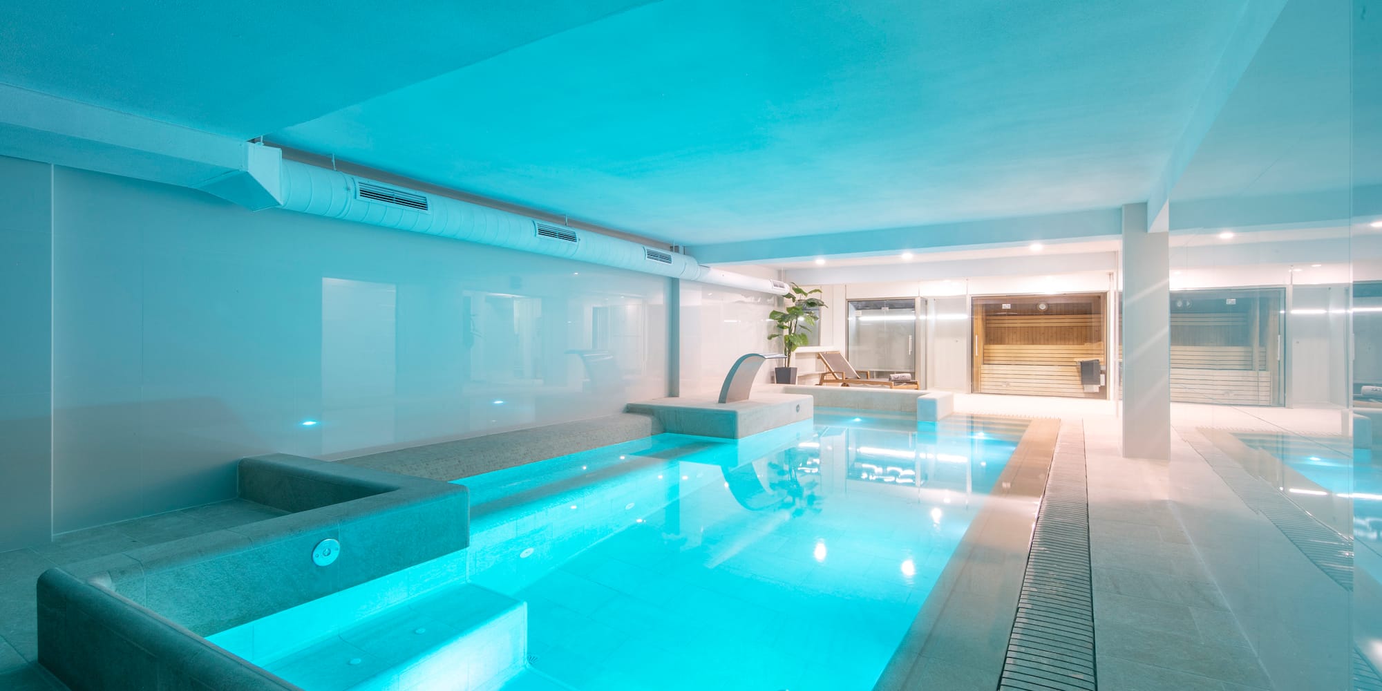 a indoor pool with a deck and a chair