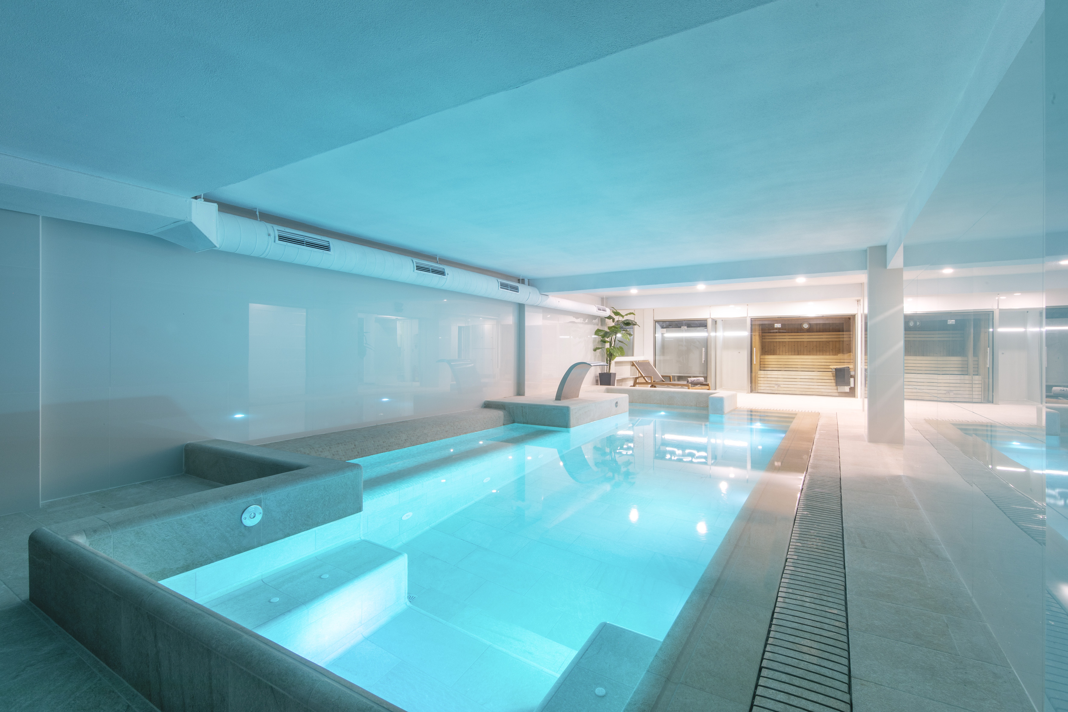 a indoor pool with a deck and a chair
