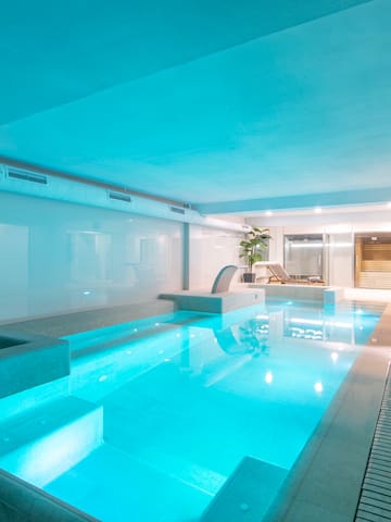 a indoor pool with a deck and a chair