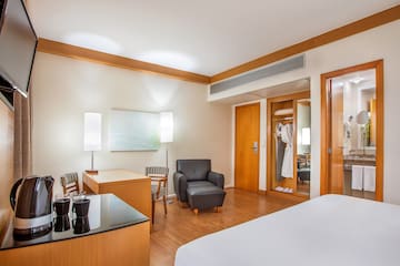 a room with a bed and a chair and a table