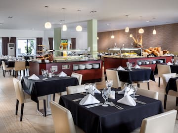 a restaurant with black tablecloths and white chairs