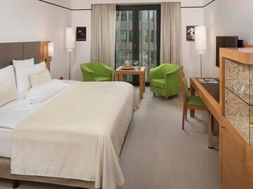 a room with a bed and a table and chairs
