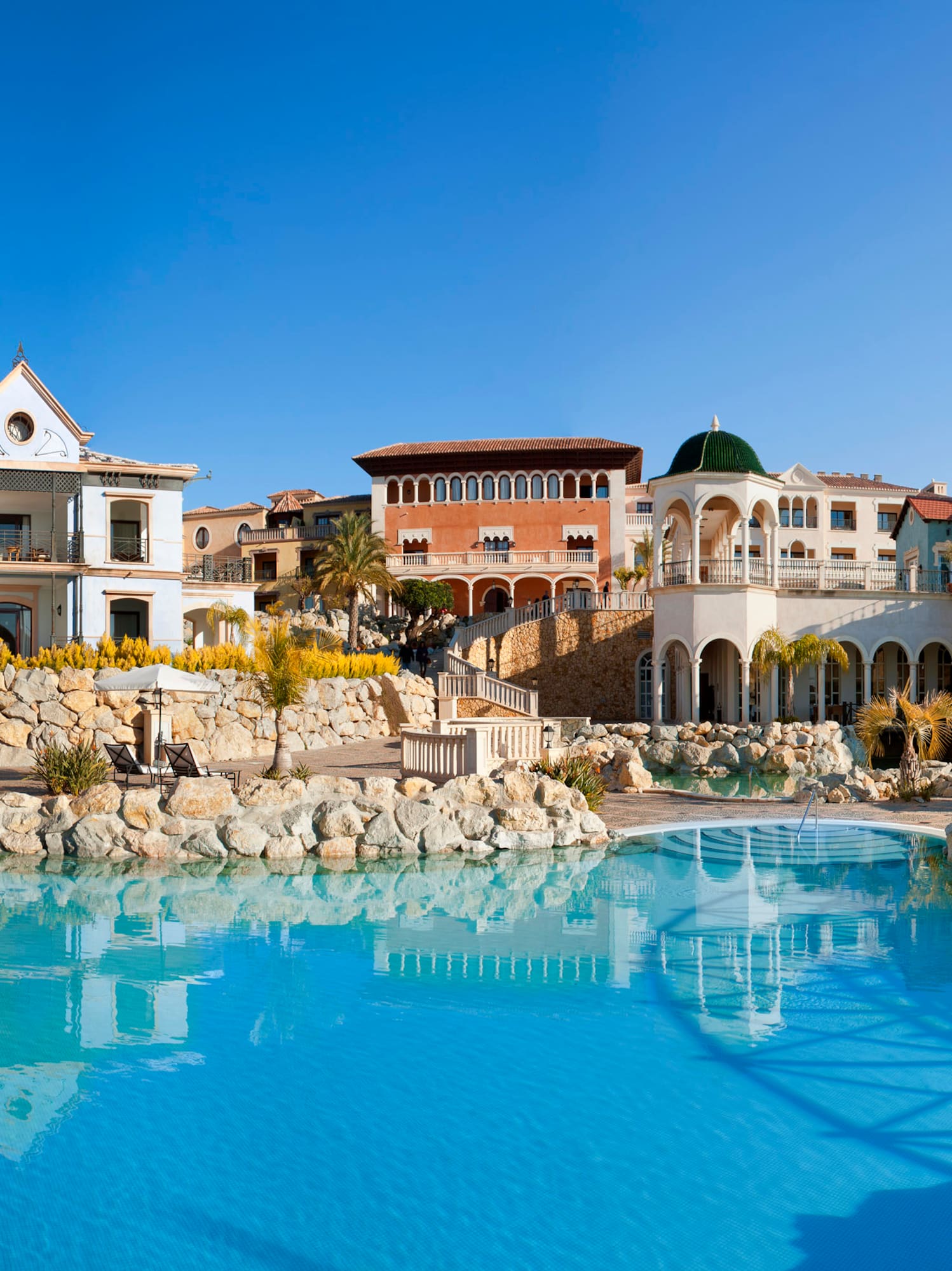 a pool with buildings and a stone wall
