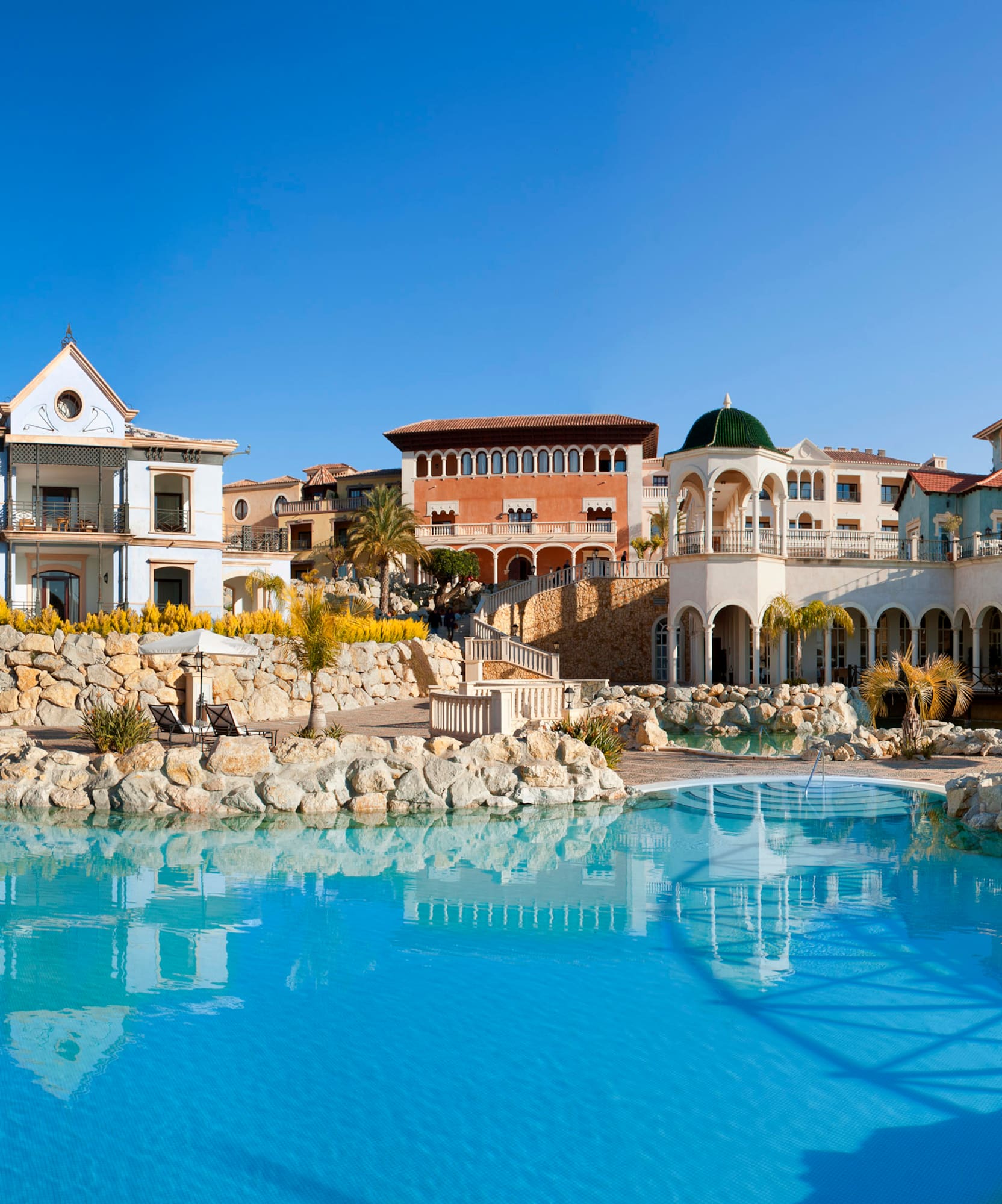 a pool with buildings and a stone wall