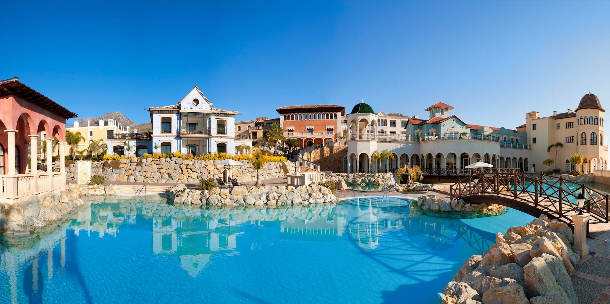 a pool with buildings and a stone wall