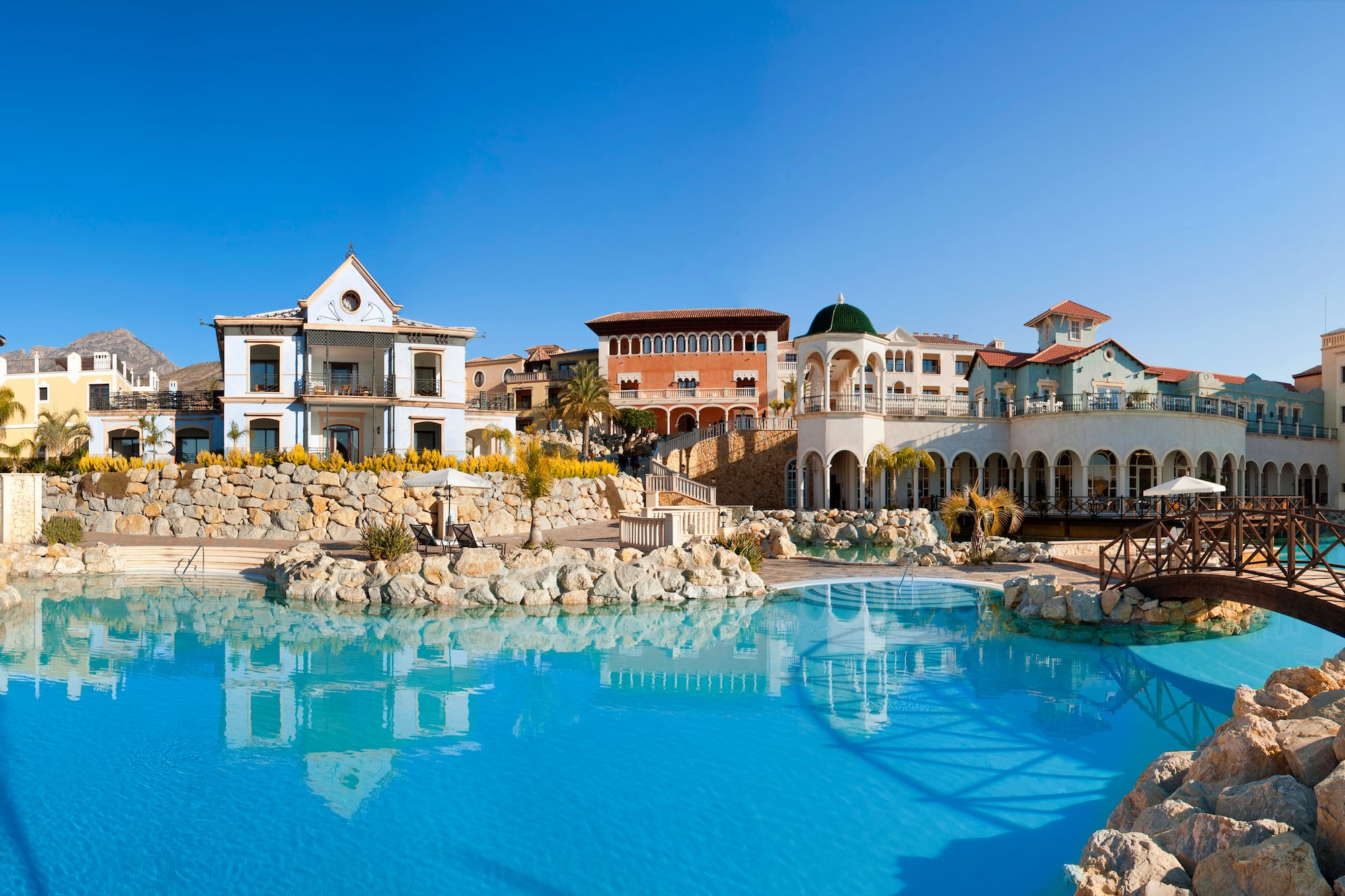 Colorful Mediterranean luxury resort with a large outdoor swimming pool.