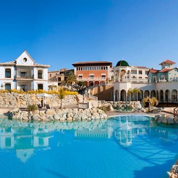 a pool with buildings and a stone wall