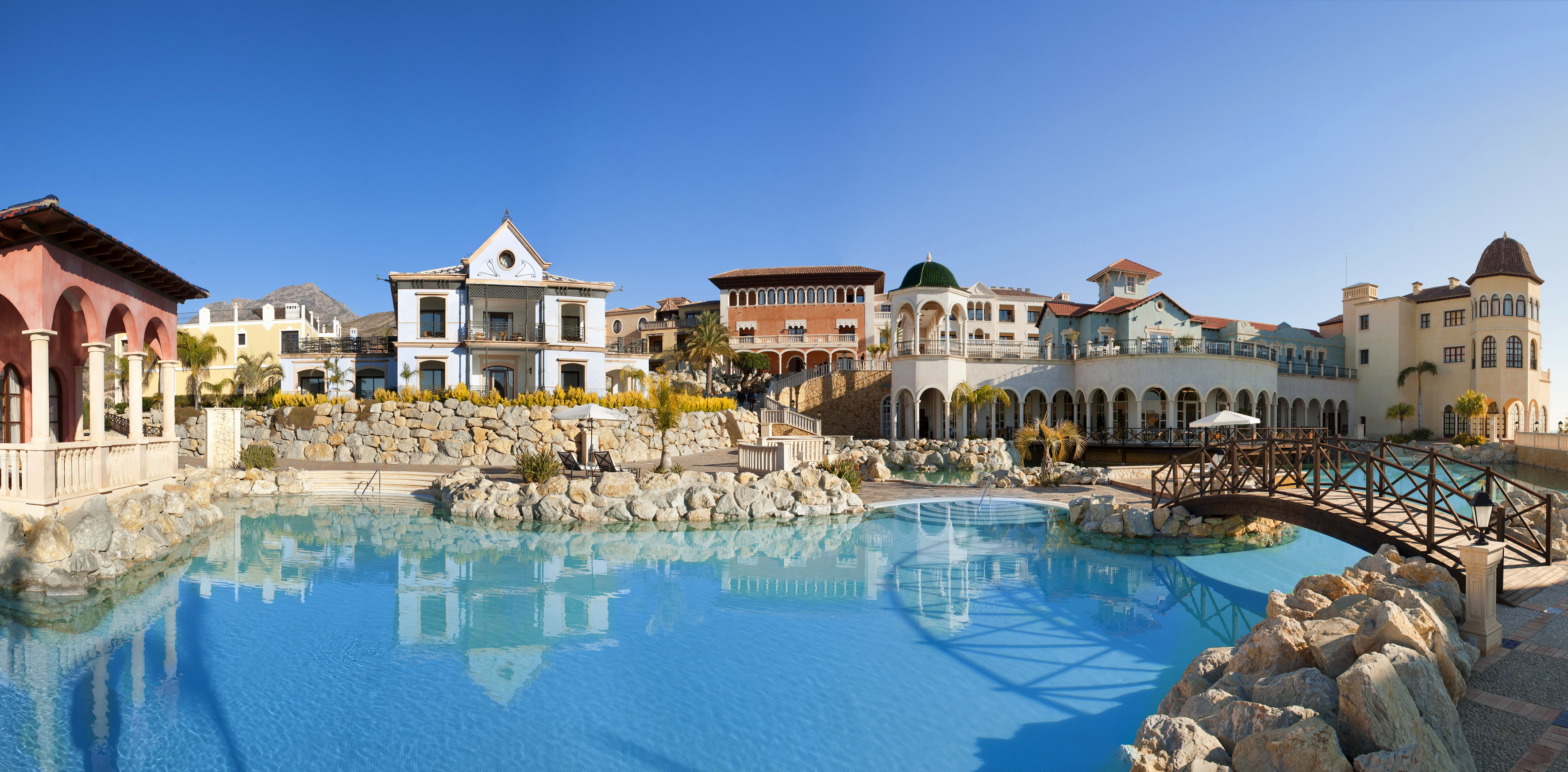 a pool with buildings and a stone wall