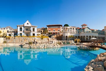a pool with buildings and a stone wall