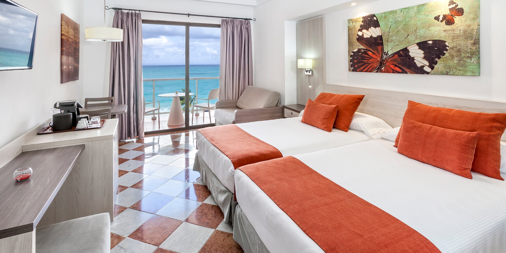 a room with two beds and a view of the ocean