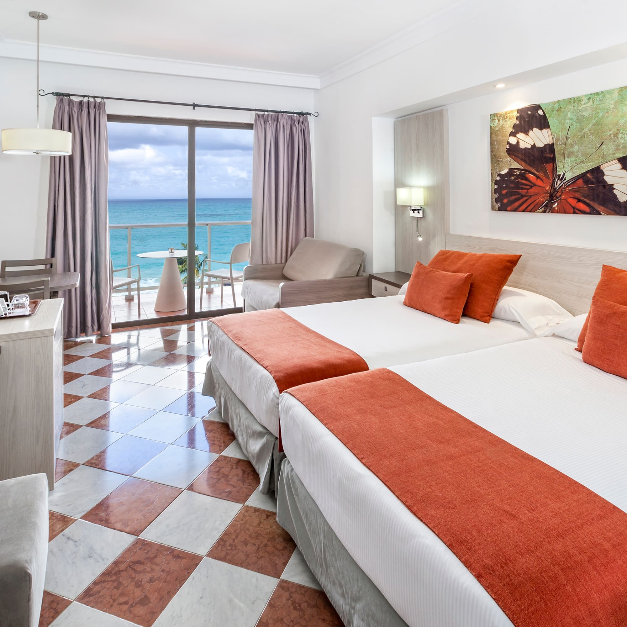 a room with two beds and a view of the ocean