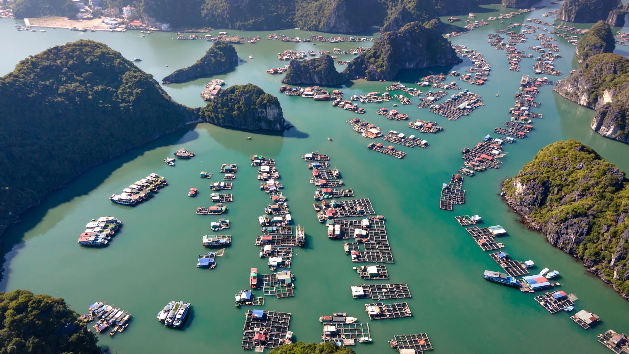 a aerial view of a body of water with boats and islands