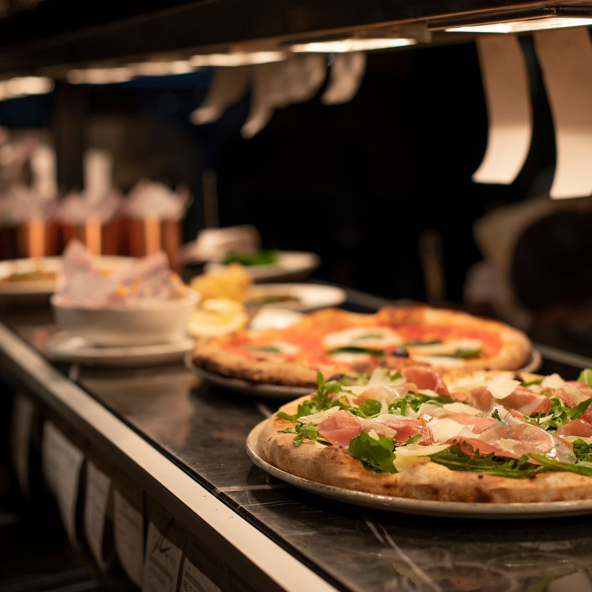 a person pouring a lime over oysters