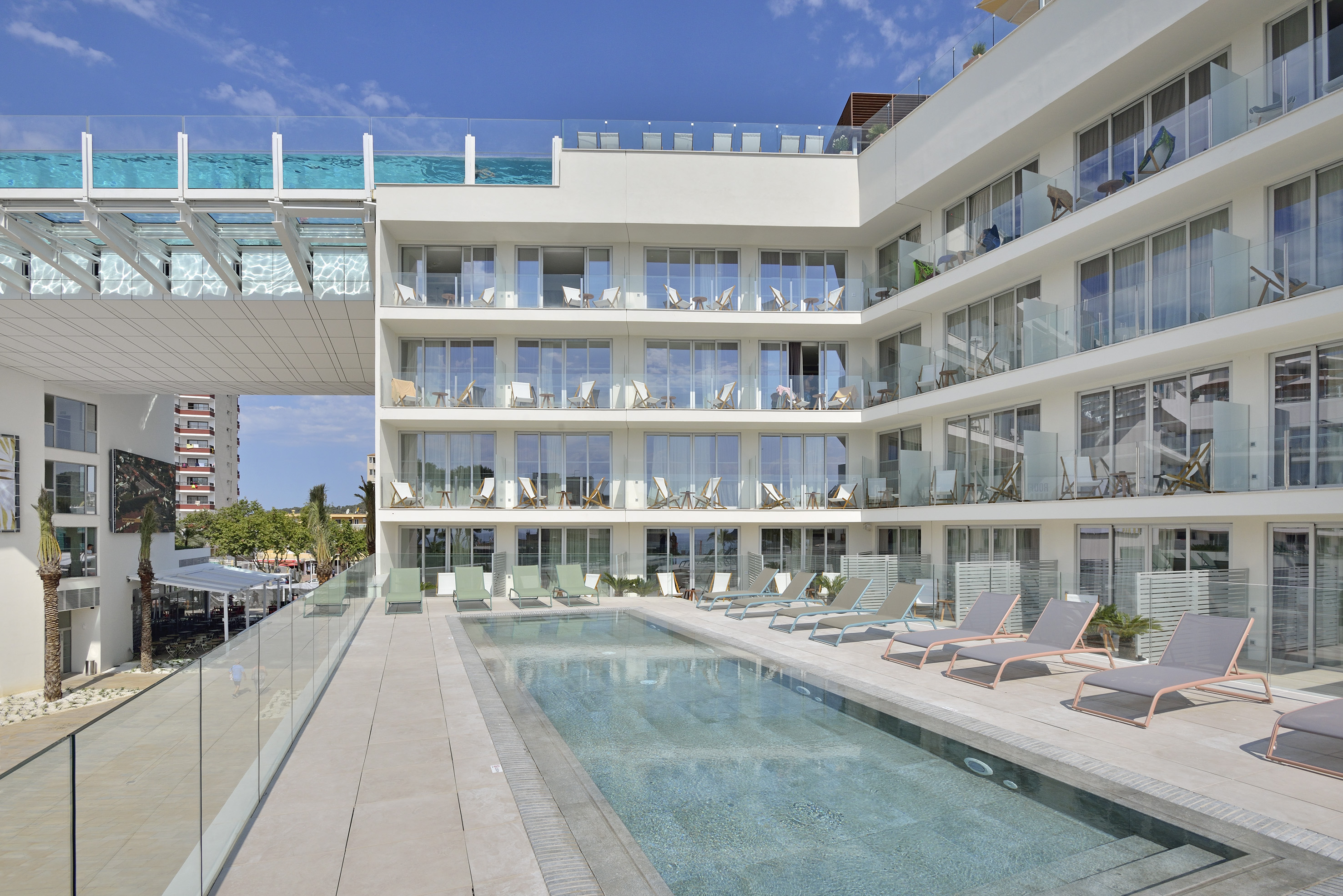 Modern hotel with outdoor swimming pool and elevated glass bridge pool.