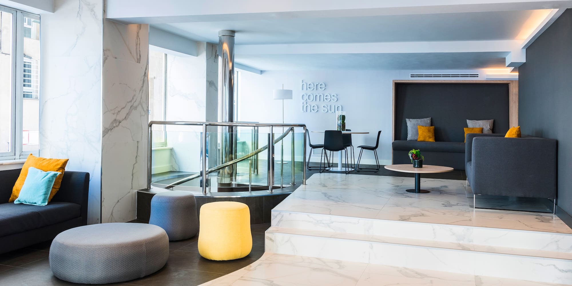 a room with a marble floor and a couch and a staircase