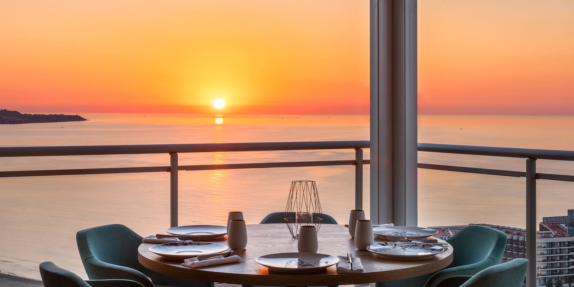 a table with plates and plates on it and chairs on the side of the table
