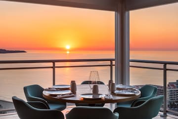 a table with plates and plates on it and chairs on the side of the table